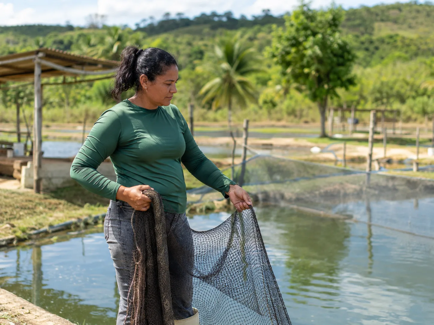Produtora rural vistoriando viveiro de aquicultura